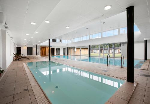 a large swimming pool in a building at Hotel/ Apartments Marina in Grenå