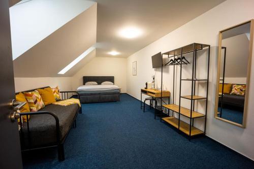 ein Schlafzimmer mit einem Bett, einem Sofa und einem Spiegel in der Unterkunft Penzion 7 pokojů in Znojmo