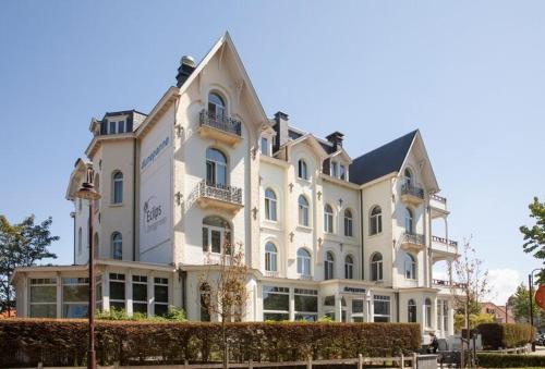 a large white building with a lot of windows at Hotel Dunepanne in De Haan