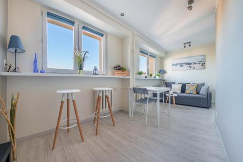a living room with a couch and a table at Apartamenty Sun & Snow Partyzantów in Gdynia