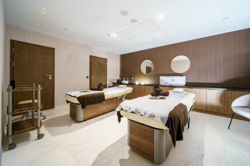 シフィエラドゥフ・ズドルイにあるElements Hotel&Spaの病室にはベッド2台と鏡が備わります。