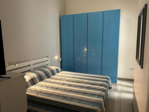 Campomarino的住宿－A 100metri dal mare difronte alla torre saracena.，一间卧室配有一张床和一个蓝色的橱柜