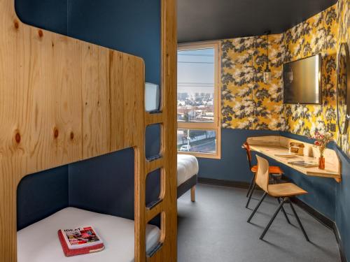 a room with a bunk bed and a desk and a deskablish at Eklo Lyon in Vénissieux