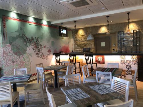 um restaurante com mesas e cadeiras brancas e uma parede em Hotel Villa México em Faramentaos