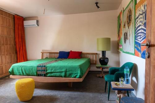 um quarto com uma cama verde e uma cadeira em Le Bunker, design apartment em Dakar