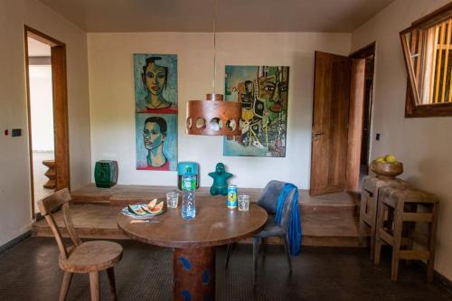 a room with a table and chairs and paintings at Le Bunker, design apartment in Dakar