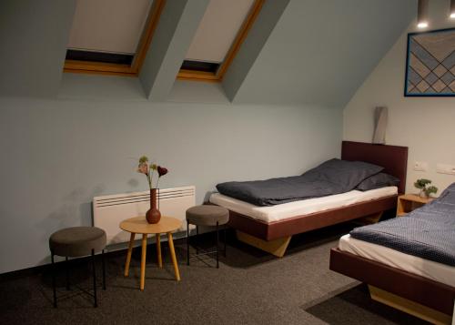 a room with two beds and a table and chairs at Bornemisza Kúria Wellness Resort in Tiszabecs