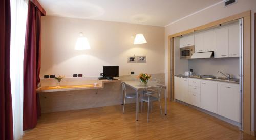 a kitchen with a table and chairs in a room at AlbaResidence Masera26 in Alba