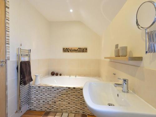 a bathroom with a tub and a sink at Ty Arwen in Penrhos-Lligwy