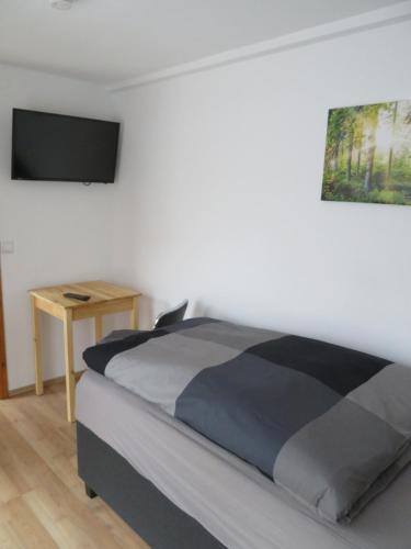 1 dormitorio con 1 cama y TV en la pared en Monteurzimmer en Dresden