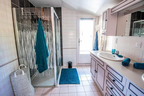 a bathroom with a shower and a sink and a mirror at Maison familiale in Moncoutant