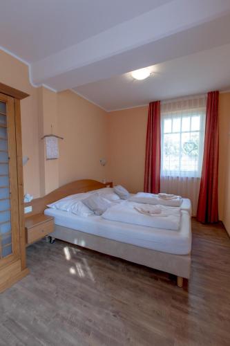 a bedroom with a large white bed in front of a window at Villa-Senta-Apartment-1 in Kühlungsborn