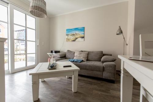uma sala de estar com um sofá e uma mesa em Villa-Borwin-Apartment-1 em Kühlungsborn