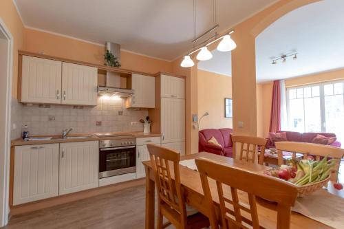 eine Küche und ein Esszimmer mit einem Tisch und Stühlen in der Unterkunft Villa Senta Apartment 2 in Kühlungsborn
