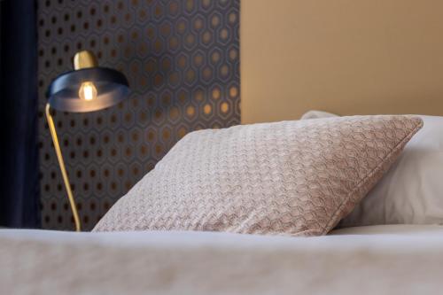 a bed with a pillow and a lamp on it at Navona 49 Luxury Suites&Apartment in Rome