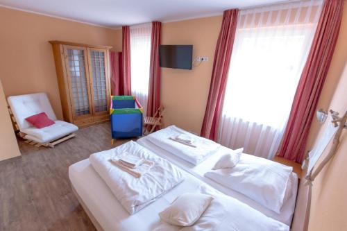 a bedroom with two white beds and a chair at Villa-Senta-Apartment-8 in Kühlungsborn