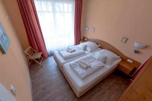 a bedroom with two beds and a large window at Villa-Senta-Apartment-9 in Kühlungsborn