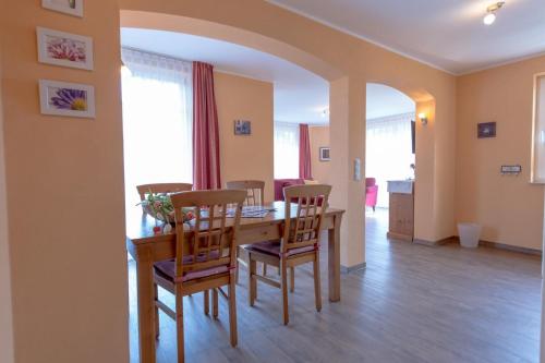 uma sala de jantar com uma mesa de madeira e cadeiras em Villa-Senta-Apartment-11 em Kühlungsborn