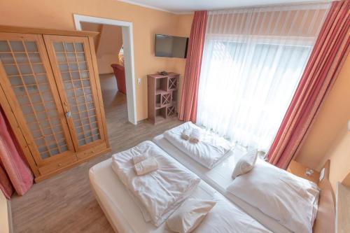 een slaapkamer met een wit bed en een groot raam bij Villa-Senta-Apartment-12 in Kühlungsborn