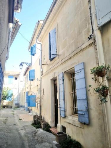 alejka z niebieskimi okiennicami na budynku w obiekcie Arles : maison provençale aux arènes. w mieście Arles