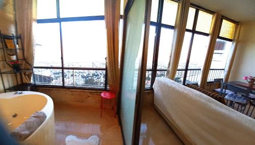 a bathroom with a bath tub in a room with windows at Amazing Panorama Bay view 3 room flat in Haifa