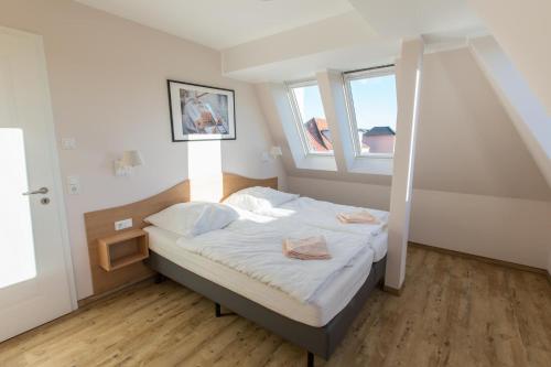 a small bedroom with a bed with a window at Sunnevelt-Apartment-10 in Kühlungsborn