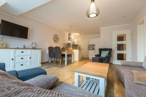 ein Wohnzimmer mit einem Sofa und einem Tisch in der Unterkunft Sunnevelt Apartment 12 in Kühlungsborn