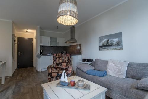 - un salon avec un canapé et une table dans l'établissement Villa-Borwin-Apartment-12, à Kühlungsborn