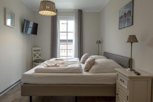 a bedroom with a large bed with a window at Villa-Borwin-Apartment-13 in Kühlungsborn