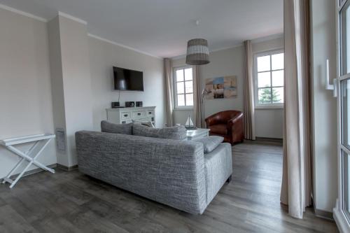 een woonkamer met een bank en een stoel bij Villa-Borwin-Apartment-18 in Kühlungsborn