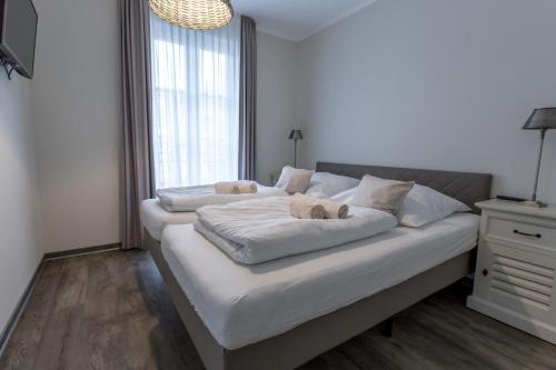 - un grand lit blanc avec 2 oreillers dans l'établissement Villa-Borwin-Apartment-8, à Kühlungsborn