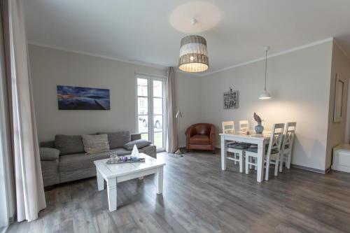 ein Wohnzimmer mit einem Sofa und einem Tisch in der Unterkunft Villa Borwin Apartment 7 in Kühlungsborn