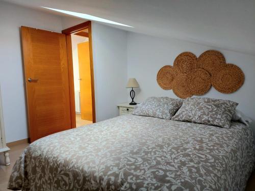 a bedroom with a large bed and a wooden door at Aromas del Jiloca in Calamocha