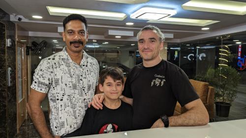 two men and a boy posing for a picture at Dreams Paradise Airport Residency in Nedumbassery