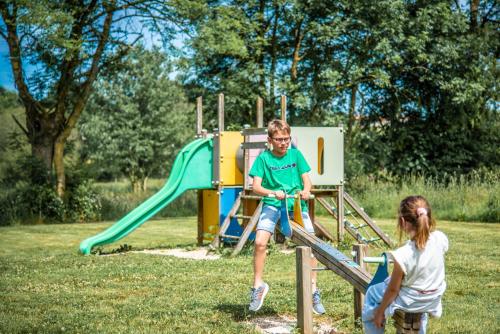 a boy and a girl playing on a playground at Maison familiale in Moncoutant