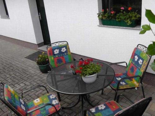 een terrastafel met stoelen en een tafel met bloemen bij Ferienhaus am Hain Naturschutzgebi in Eldena