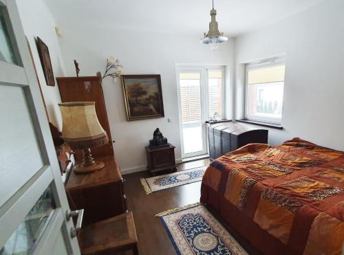 Un dormitorio con una cama y una lámpara. en Keturių kambarių namas,Vilnius, en Riešė