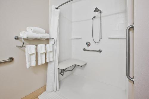 W łazience znajduje się prysznic i białe ręczniki. w obiekcie Holiday Inn Express Hotel & Suites Cincinnati Northeast-Milford, an IHG Hotel w mieście Milford