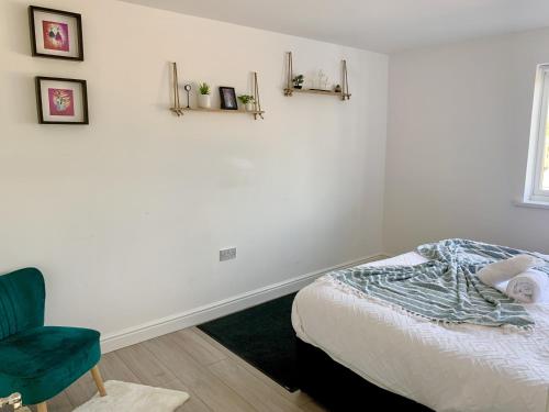 - une chambre avec un lit et une chaise verte dans l'établissement Cosy 2 bedrooms apartment in Birmingham, à Birmingham