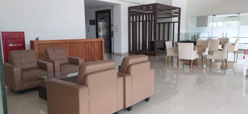 een wachtruimte met stoelen en een tafel in een gebouw bij Newton Apartment Residence By Ayulian in Bandung