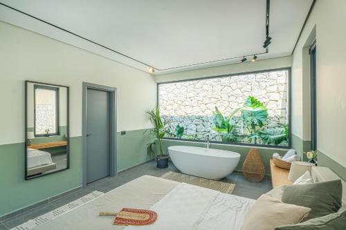 een badkamer met een bad en een groot raam bij Viohouses - Luxury Private Pool Villas Fethiye in Fethiye