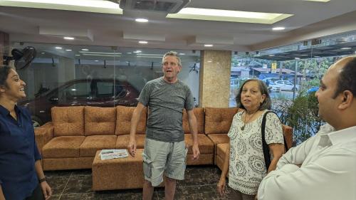 a group of people standing in a living room at Dreams Paradise Airport Residency in Nedumbassery
