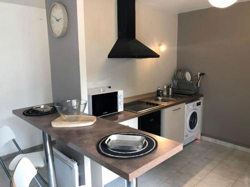 - une cuisine avec un comptoir, un évier et une cuisinière dans l'établissement Echoppe Bordelaise chaleureuse, à Bordeaux