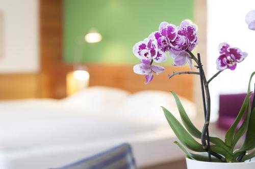 a vase filled with purple flowers on a table at Hotel Heubad in Fiè