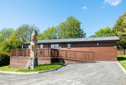 a house with a fence and a driveway at Tawny Lodge with Hot Tub in Cupar