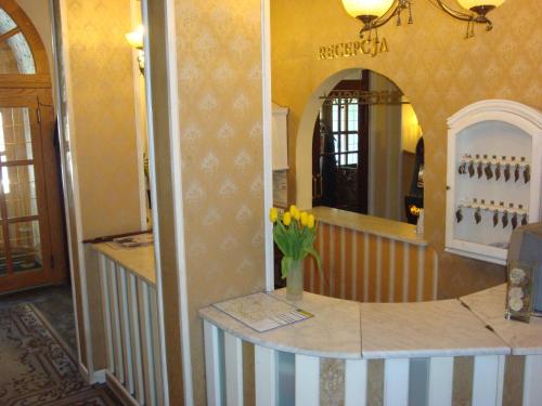 Pokój z ladą z wazonem kwiatów w obiekcie Hotel Bristol w Tarnowie