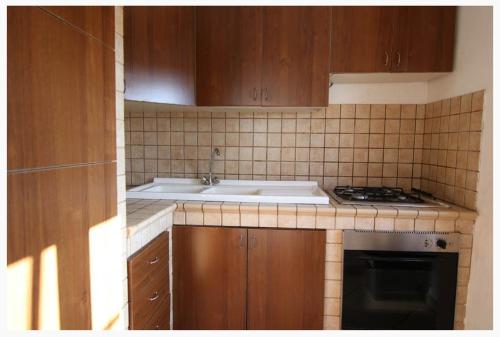 a kitchen with a sink and a stove at Villette Ninfee in Marina di Mancaversa