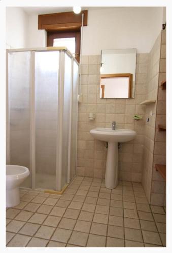 a bathroom with a shower and a sink and a toilet at Villette Ninfee in Marina di Mancaversa