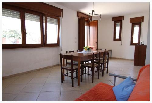 a living room with a dining room table and chairs at Villette Ninfee in Marina di Mancaversa