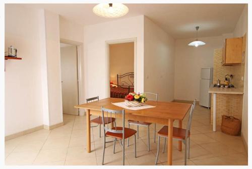 a dining room table and chairs in a kitchen at Villette Ninfee in Marina di Mancaversa